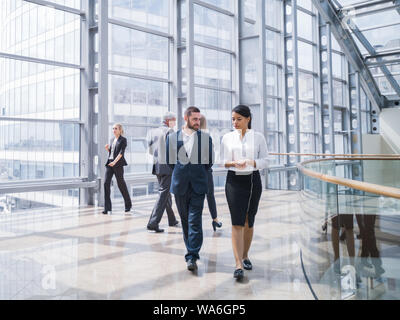 Business people walking in a modern hall of office building Stock Photo