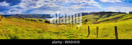 Green grazing farm land around Lake Lyell in Blue Mountains of Australia - life style agricultural cattle paddock fenced on hillsides in wide panorami Stock Photo