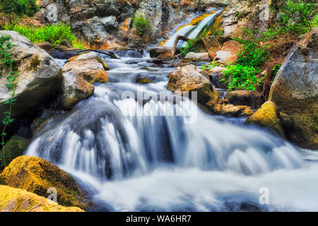 Fast stream of Jenolan river in Blue Mountains of Australia flowing from Blue Lake off Jenolan caves and village between heavy rocks. Stock Photo