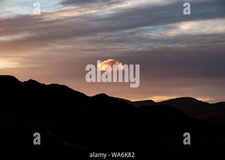 Single cloud above mountain silhouette (English Lake District) Stock Photo