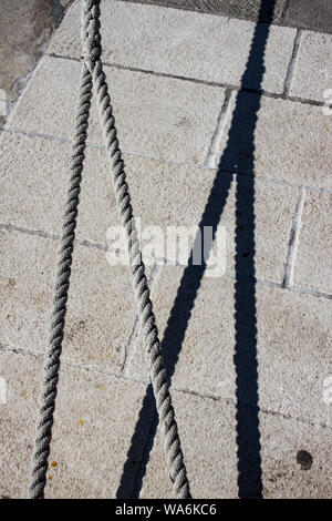 Ship cord or ropes with shadow gives M letter as a mooring, as Marina, as marina etc Stock Photo