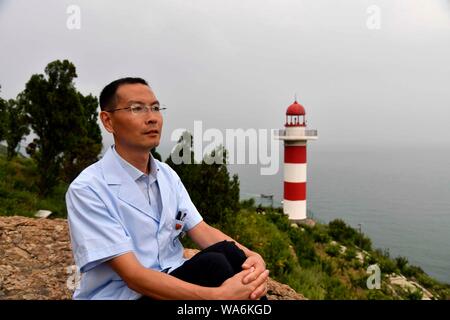 (190818) -- QINGDAO, Aug. 18, 2019 (Xinhua) -- Doctor Zhou Zhaojing is seen on the Lingshan Island of Qingdao, east China's Shandong Province, Aug. 16, 2019. The Lingshan Island is located some nine sea miles southeast off the west coast of Qingdao. Since 2013, the west coast new area has dispatched medical staff members to work by turns on the island. The 40-year-old Zhou was selected in 2018 as a general practitioner to work at the island's health service center. Despite harsh working and living conditions, Zhou and his colleagues never get slack at their work to provide medical service to s Stock Photo