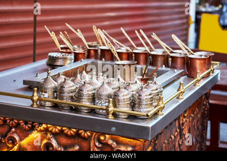 Traditional copper Turkish coffee cups and coffee pots cooked in hot sand on the service table Stock Photo