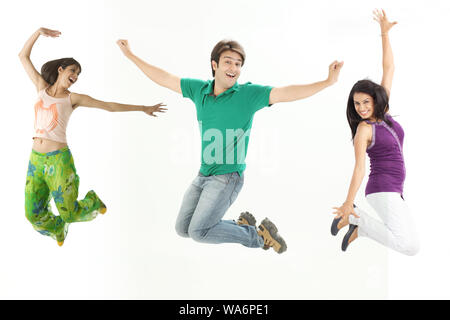 Group of friends jumping in mid air and smiling Stock Photo