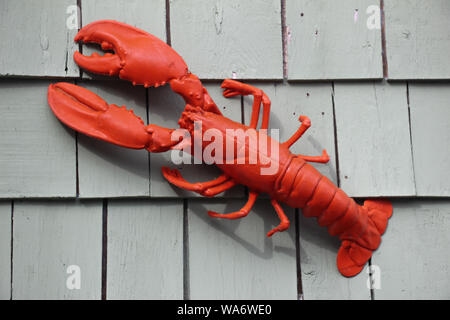red lobster hanging on a wood shingled wall of a building Stock Photo