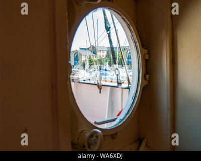The Helwick Light Vessel at dock in Swansea Marina. Looking out of a porthole window. Swansea, Wales, UK. Stock Photo