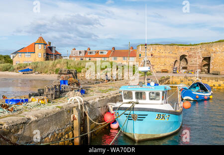 Small fishing boats moored in Beadnell Bay Harbour. Stock Photo