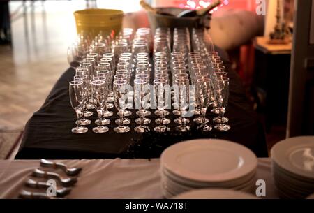 Shot of assorted champagne glasses on a table near dishware Stock Photo