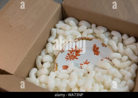Herend Porcelain Plate is Safely Packed in Box with Styrofoam Peanuts Stock Photo