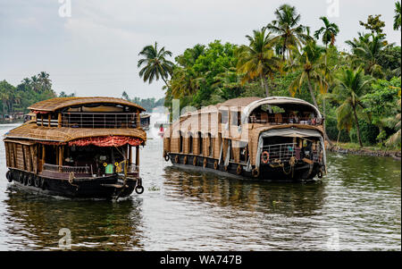 ALLEPPEY, INDIA, MAR 13, 2018: Bamboo thatched houseboat floats down the backwaters of Kerala Stock Photo