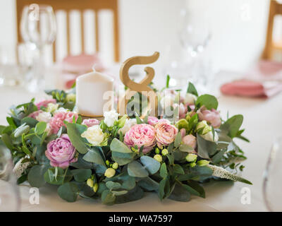 Wedding table decorations with flowers, candles and numbers Stock Photo