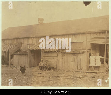 We give them houses to live in. About 50 persons housed in this miserable row of dilapidated shacks, located on an old shell-pile, and partly surrounded by a tidal marsh. Maggioni Canning Co. Abstract: Photographs from the records of the National Child Labor Committee (U.S.) Stock Photo