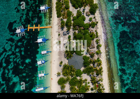 Aerial drone view of traditional Banca boats moored next to a tiny, tropical island surrounded by coral reef (Kalanggaman Island) Stock Photo