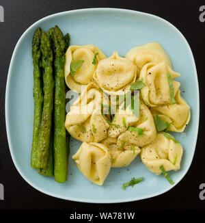 Ravioli with asparagus on a blue plate Stock Photo