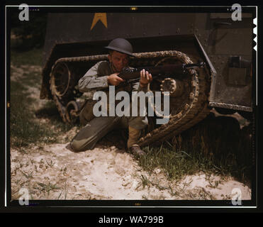 A young soldier of the armored forces holds and sights his Garand rifle like an old timer, Fort Knox, Ky. He likes the piece for its fine firing qualities and its rugged, dependable mechanism. Infantryman with halftrack Stock Photo