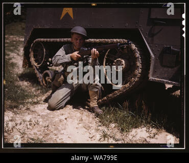 A young soldier of the armored forces holds and sights his Garand rifle like an old timer, Fort Knox, Ky. He likes the piece for its fine firing qualities and its rugged, dependable mechanism. Infantryman with halftrack Stock Photo