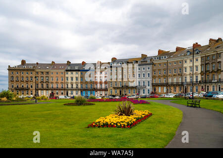 Royal Crescent a curved terrace of 19th Century six storey town houses on West Cliff Whitby facing on a formal flower garden Stock Photo