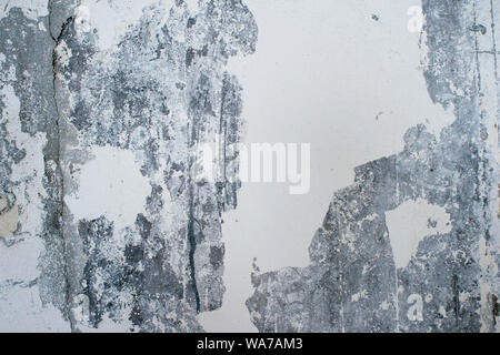 Stripped concrete wall with remnants of white plaster and paint. Background. Stock Photo