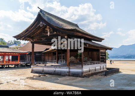 Japan, Miyajima. Itsukushima Shrine. The Noh stage, from 1680, constructed in Ichiju-kiritsuma style with thatched cypress roof. Tide out. Stock Photo