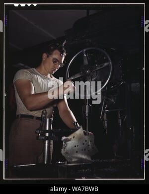 An employee in the drill-press section of North American's huge machine shop runs mounting holes in a large dural casting, Inglewood, Calif. This plant produces the battle-tested B-25 (Billy Mitchell) bomber, used in General Doolittle's raid on Tokyo, and the P-51 (Mustang) fighter plane which was first brought into prominence by the British raid on Dieppe Stock Photo