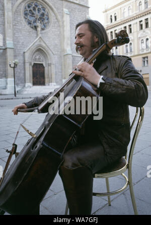 11th May 1993 During the Siege of Sarajevo: the 'cellist of Sarajevo', Vedran Smailović, performs in front of the Sacred Heart Cathedral. Stock Photo