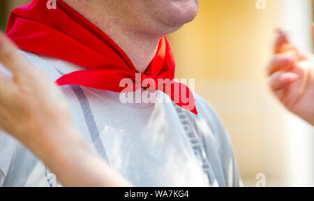 Woman ties red silk neckerchief to a man Stock Photo