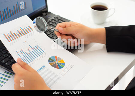 Businesswoman with financial documents using laptop at desk Stock Photo