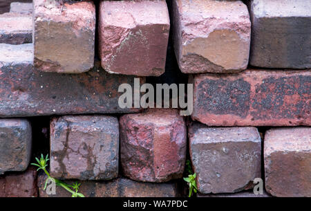 Old stacked bricks in a wall make a pretty patterns of textures and color Stock Photo
