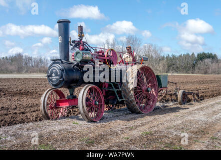 April 28 2018 Buchanan MI USA; antique steam tractor demonstrates how to plow a field during an event in this small Michigan town Stock Photo