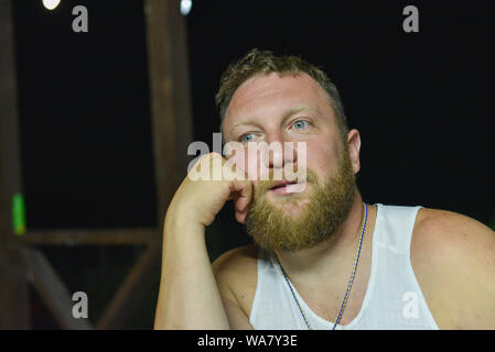Red bearded hipster in summer time. A man with a red beard in a white shirt. Brutal man is sad. The guy looks thoughtfully.Portrait of a man's face an Stock Photo