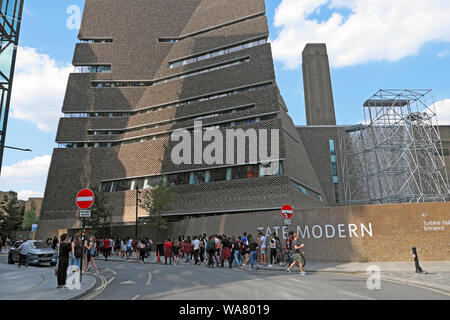 Queue of European visitors students walking in the street near the Tate Modern Art Gallery extension South London England UK  KATHY DEWITT Stock Photo