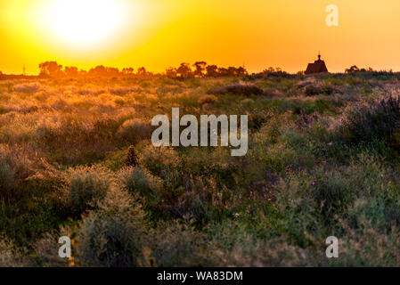 Bright sun in an orange sky with clouds at sunset. Stock Photo