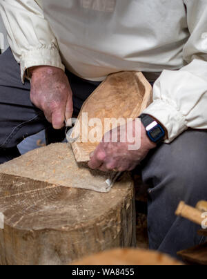 An artist holds a  demonstration on hand carving a wooden bowl Stock Photo