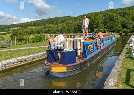 BATH, ENGLAND - JULY 2019: Narrow boat with people on board sailing over the Dundas Aquaduct on the Kennet & Avon Canal near the city of Bath Stock Photo