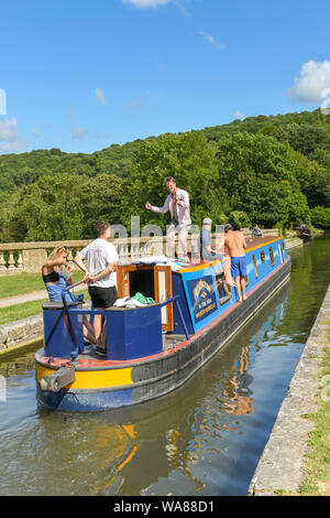 BATH, ENGLAND - JULY 2019: Narrow boat with people on board sailing over the Dundas Aquaduct on the Kennet & Avon Canal near the city of Bath Stock Photo