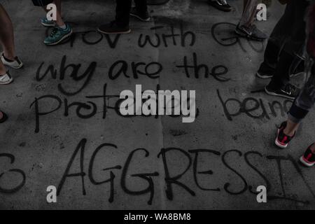 Graffiti with an anti-violence message at the footbridge floor during the demonstration.Protesters took to the streets on a rainy Sunday in a pro-democracy demonstration on Hong Kong Island, They demand the complete withdraw of the extradition bill and the government to set up an independent inquiry into the recent clashes between protesters and police - Organisers stated that this was the largest rally during the week. Stock Photo