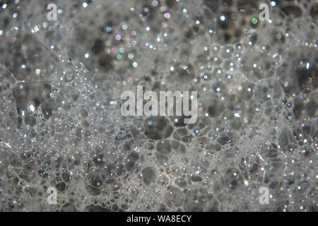 Bubbles in foamy water reflecting light. Stock Photo