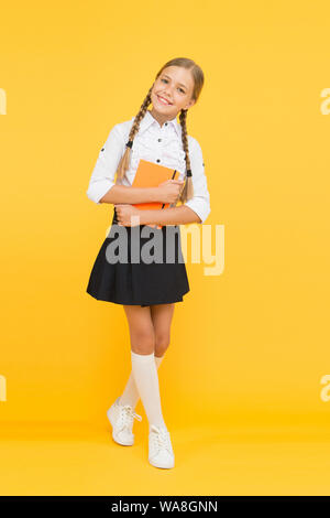 Inspired to work hard. happy girl study hard with notebook. literature lesson. childrens literature. small girl child with book. back to school. Pupil at book store or library. reading and writing. Stock Photo