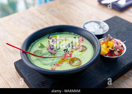 Green vegetable soup with mangold, crab meat and mango on black wooden board Stock Photo