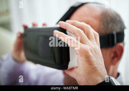 Close-up image of man putting on his new virtual reality glasses to play video game or enjoy movie Stock Photo