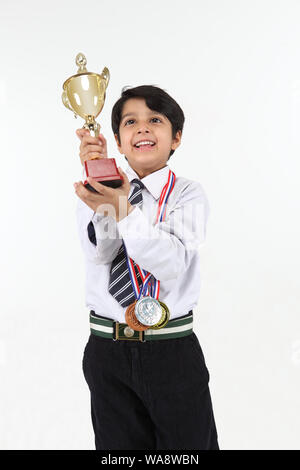 Schoolboy showing a trophy and smiling Stock Photo