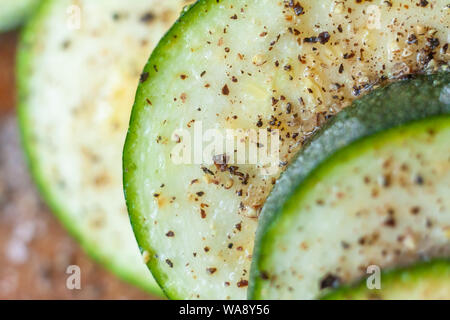 Zucchini slices sprinkled with salt and herbs. Raw zucchini in close-up. Stock Photo