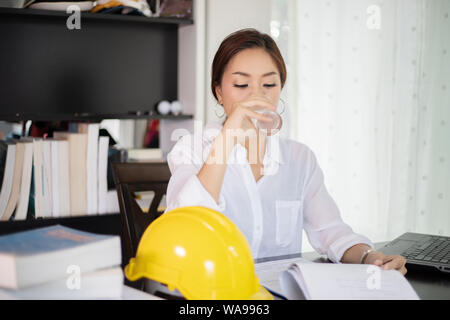 Asian business women and women engineering using notebook for working and drinking water Stock Photo