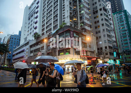 Hong Kong, China. 18th Aug, 2019. Demonstrators protect themselves with umbrellas from the persistent rain. In the former British crown colony of Hong Kong, protests against the influence of Beijing have entered a new round. The democracy movement had called for another major demonstration. Credit: Gregor Fischer/dpa/Alamy Live News Stock Photo