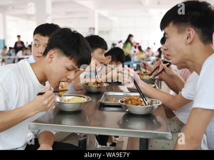 Chinese students eat lunch in the canteen at a senior high school in Luocheng Mulam Autonomous County, south China's Guangxi Zhuang Autonomous Region, Stock Photo