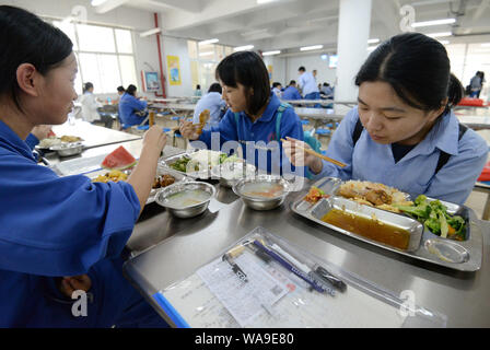 Chinese students eat lunch in the canteen at a high school in Handan city, north China's Hebei province, 6 June 2017. Stock Photo