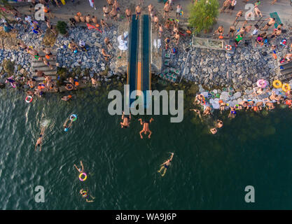 Local residents gather and dive into the Han River to cool off on a scorching day in Xiangyang city, central China's Hubei province, 22 July 2019. Stock Photo