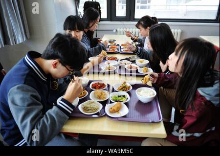 Chinese students eat lunch in the canteen at a school in Qingdao city, east China's Shandong province, 20 April 2017. Stock Photo