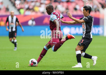 Italian football players Angelo Ogbonna of West Ham United F.C., the black man, keeps the ball during the Premier League Asia Trophy against Newcastle Stock Photo