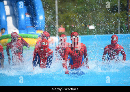 Chinese staff memers dressed as Spider-Man play in a swimming pool during a flash mob event at a water park to escape heat wave in Chongqing, China, 2 Stock Photo